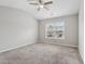 Well-lit bedroom with a ceiling fan and large window overlooking the neighborhood at 2785 Maple Park Pl, Cumming, GA 30041