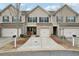 Charming townhome featuring a brick facade, covered porch, and a two car garage at 2785 Maple Park Pl, Cumming, GA 30041