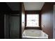 Bathroom with a jetted tub, walk-in shower, and decorative window adding charm at 838 Roxholly Ln, Buford, GA 30518