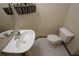 Cozy bathroom with pedestal sink, toilet, decorative basket and mirror at 838 Roxholly Ln, Buford, GA 30518