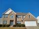 Traditional brick two-story home with attached garage and manicured landscaping on a sunny day at 838 Roxholly Ln, Buford, GA 30518