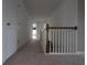 Bright hallway featuring neutral carpeting and a traditional white railing at 838 Roxholly Ln, Buford, GA 30518