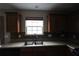 Kitchen features stainless steel sink, window, and wood cabinets at 838 Roxholly Ln, Buford, GA 30518