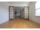 Open room with wood floors, french doors, and natural light from a nearby window at 838 Roxholly Ln, Buford, GA 30518