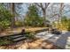 Relaxing backyard featuring a stone patio with dining furniture, lush landscaping, and mature trees at 1881 Edinburgh Ne Ter, Atlanta, GA 30307