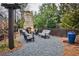 Backyard with gravel, a fireplace, patio furniture, and tall green trees at 4454 Dandelion Ln, Atlanta, GA 30342