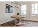 Bright dining area with clear acrylic chairs, round wood table, modern pendant lighting, and wood floors at 4454 Dandelion Ln, Atlanta, GA 30342