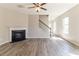 Open-concept living room with fireplace and staircase, complemented by natural light at 6399 Woodwell Dr, Union City, GA 30291
