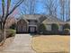 Charming brick home with a landscaped front yard and a long, curved driveway leading to the entrance at 1140 Matheson Way, Alpharetta, GA 30022