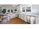 Bright kitchen with white cabinets, hardwood floors, stainless steel appliances, and sunroom access at 1140 Matheson Way, Alpharetta, GA 30022