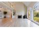 Sun-filled living room featuring hardwood floors, a fireplace, large windows, and a vaulted ceiling at 1140 Matheson Way, Alpharetta, GA 30022