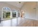 Bright living room featuring hardwood floors, fireplace, tall arched windows and an adjacent staircase at 1140 Matheson Way, Alpharetta, GA 30022