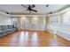 Spacious living room with hardwood floors, ceiling fan, and ample natural light from the windows and doors at 1140 Matheson Way, Alpharetta, GA 30022