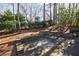 Stone patio featuring outdoor seating and views of a lush, wooded backyard at 1140 Matheson Way, Alpharetta, GA 30022