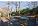 Stone patio featuring outdoor seating and views of a lush, wooded backyard at 1140 Matheson Way, Alpharetta, GA 30022