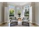 Cozy seating area with large bay windows, plantation shutters, hardwood floors, and comfortable armchairs at 1140 Matheson Way, Alpharetta, GA 30022