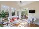 Bright sunroom boasts many windows and light, neutral decor at 1140 Matheson Way, Alpharetta, GA 30022