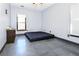 Simple bedroom featuring a minimalist platform bed, grey walls, and a large window at 3065 Kings Nw Dr, Kennesaw, GA 30144