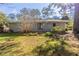 The backyard shows the exterior of a gray brick house and healthy green lawn in a landscaped setting at 1526 Colony East Cir, Stone Mountain, GA 30083