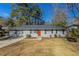 Charming single story home with a brick facade, well maintained lawn and a vibrant red front door at 1526 Colony East Cir, Stone Mountain, GA 30083