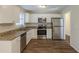 Modern kitchen featuring stainless steel appliances, granite countertops, white cabinets, and wood floors at 1526 Colony East Cir, Stone Mountain, GA 30083