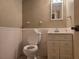 Cozy half bath featuring a toilet and vanity with a sink and mirror at 1840 Sw King Alfred Sw Dr, Atlanta, GA 30331