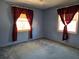 Blue bedroom featuring carpeted floors, natural light, and decorative window curtains at 1840 Sw King Alfred Sw Dr, Atlanta, GA 30331
