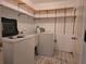 Functional laundry area with washer, dryer, sink, and storage shelves at 1840 Sw King Alfred Sw Dr, Atlanta, GA 30331