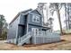 Back view of a blue two-story home featuring a large deck and staircase at 113 Miller Rd, Stockbridge, GA 30281