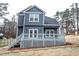 View of the back of a blue, two-story home with a deck and staircase at 113 Miller Rd, Stockbridge, GA 30281