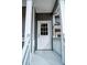 Close-up of a classic white front door with window panes, framed by gray siding and elegant white columns at 113 Miller Rd, Stockbridge, GA 30281