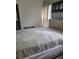 A neutral colored bedroom with large window and bed with beige quilted comforter at 2744 Snapfinger Mnr, Decatur, GA 30035