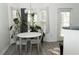 Bright dining area with a round table set beneath a modern chandelier and lush plants at 2744 Snapfinger Mnr, Decatur, GA 30035