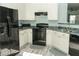 Bright kitchen showcasing white cabinets, black appliances, and a sleek countertop at 2744 Snapfinger Mnr, Decatur, GA 30035
