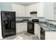 Well-lit kitchen featuring white cabinets, a black refrigerator, and gray countertops and floor at 2744 Snapfinger Mnr, Decatur, GA 30035