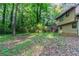 Side view of a two-story home surrounded by mature trees, grass and other greenery at 4342 Lincolndale Dr, Ellenwood, GA 30294