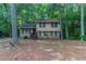 Two-story home featuring brick and siding, a wooded lot, and a quaint front porch at 4342 Lincolndale Dr, Ellenwood, GA 30294