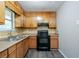 Well-lit kitchen with wooden cabinets, laminate countertops and black appliances at 4342 Lincolndale Dr, Ellenwood, GA 30294