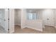 Bright hallway with white trim, doors, light gray walls, and light wood flooring leading to additional rooms at 4531 Moray Dr, Mableton, GA 30126