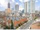 Aerial view of brick townhomes in an urban setting with a skyline backdrop at 774 Piedmont Ne Ave # 2A, Atlanta, GA 30308