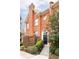 Beautiful brick townhouse with a black front door, elegant landscaping, and decorative planters at 774 Piedmont Ne Ave # 2A, Atlanta, GA 30308