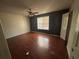 Bedroom with hardwood floor, dark accent wall, window and overhead ceiling fan at 440 Ward Rd, Ellenwood, GA 30294