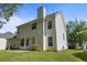 Two-story home showcasing the back exterior with a well-maintained lawn and lush greenery at 4832 Hidden Creek Pl, Decatur, GA 30035