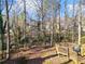 A wooded backyard with a deck, swing set, and slide at 505 Summer Ter, Woodstock, GA 30189