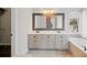 Bright bathroom featuring a double vanity, undermount sinks, decorative mirrors, and a tiled tub at 505 Summer Ter, Woodstock, GA 30189