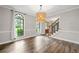 Bright dining room featuring hardwood floors, stylish chandelier, and a large window offering natural light at 505 Summer Ter, Woodstock, GA 30189