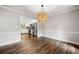 Elegant dining area with hardwood floors, designer chandelier, and a view into the modern kitchen at 505 Summer Ter, Woodstock, GA 30189