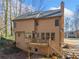 The rear exterior view of a two-story home, featuring a deck and wooded lot at 505 Summer Ter, Woodstock, GA 30189