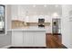 Modern kitchen with white cabinets, stainless steel appliances, and tile backsplash at 505 Summer Ter, Woodstock, GA 30189
