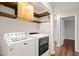 Laundry room with washer, dryer, and wooden storage cabinets at 505 Summer Ter, Woodstock, GA 30189